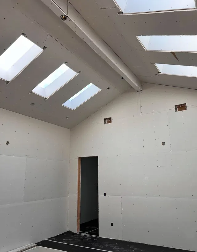 A sloped ceiling with skylights and recessed light openings.