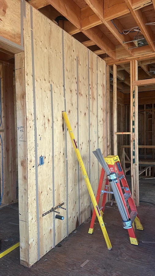Plywood wall with visible vertical strips and a level.